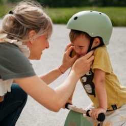 Mother fitting a Kinderfeets Silver Sage Helmet to her son