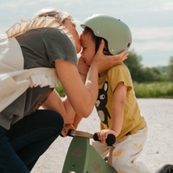 Mother fitting a Kinderfeets Silver Sage Helmet to her son